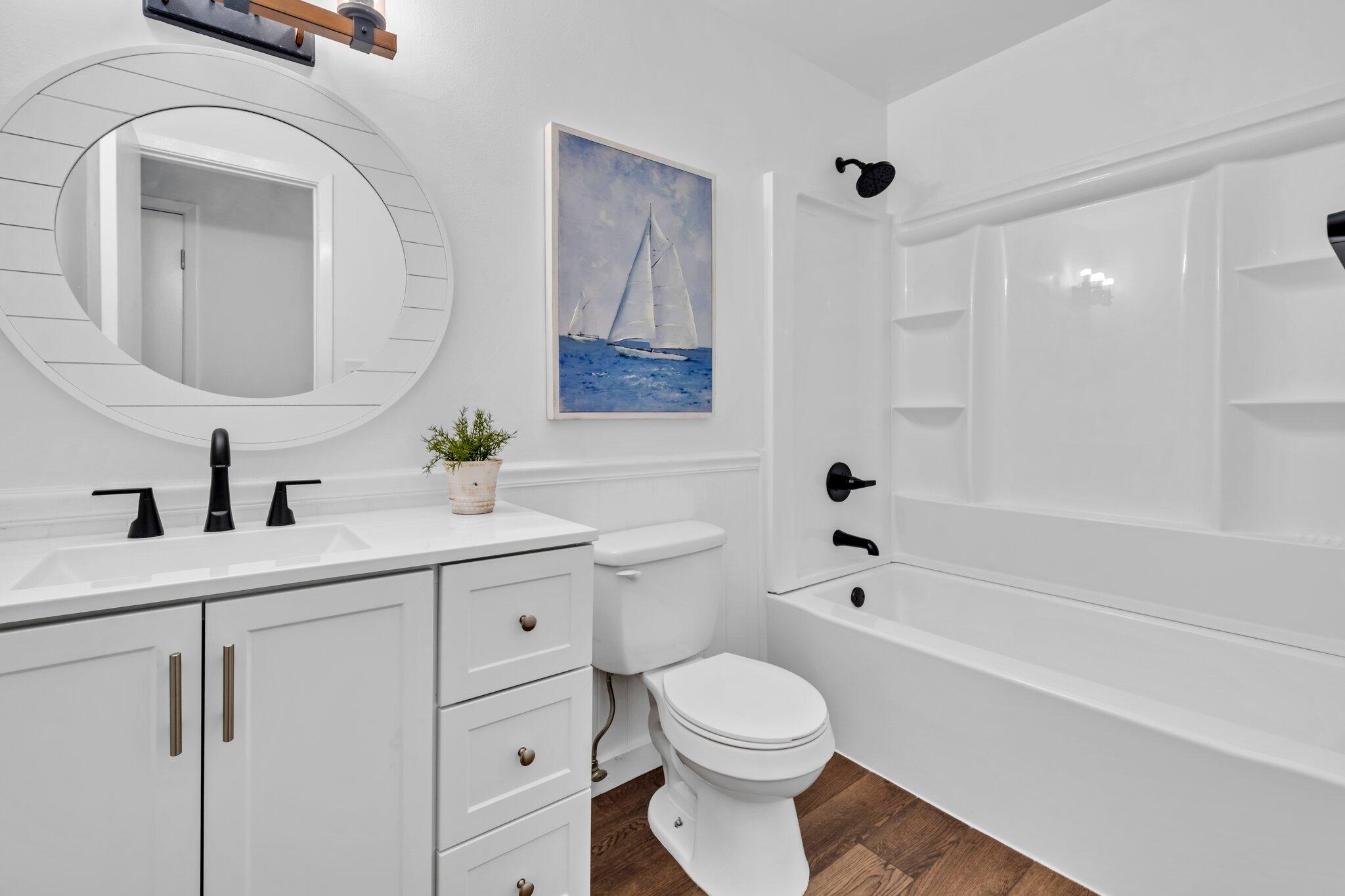 5241 Bob Sikes Road DeFuniak Springs, FL 32435 - Photo 28 of 35 a bathroom with a toilet a sink a tub and mirror
