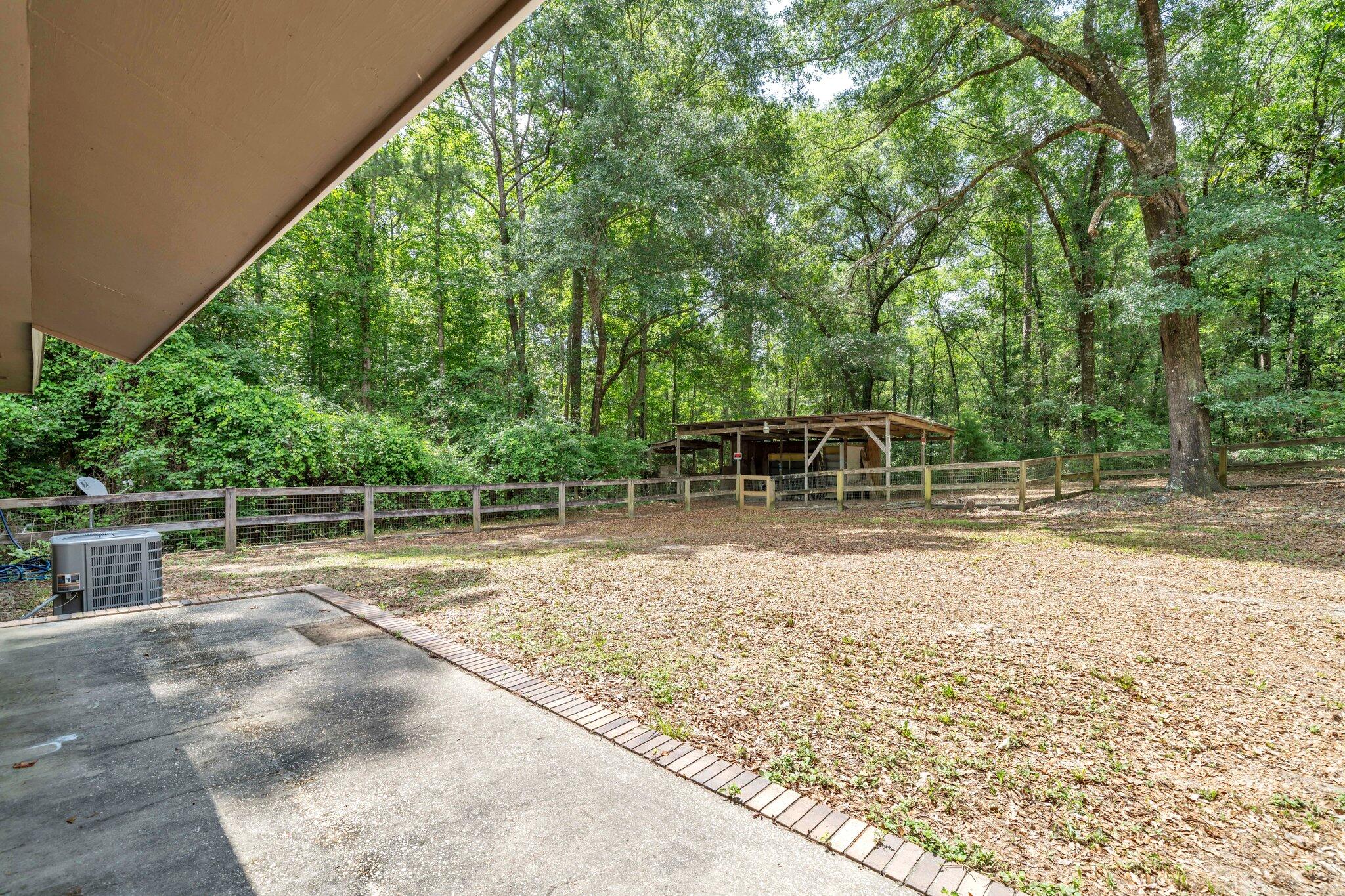 5241 Bob Sikes Road DeFuniak Springs, FL 32435 - Photo 29 of 35 a backyard of a house with table and chairs