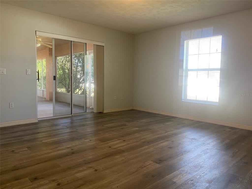 5881 Southwest 86th Place Ocala, FL 34476 - Photo 14 of 18 an empty room with wooden floor and windows