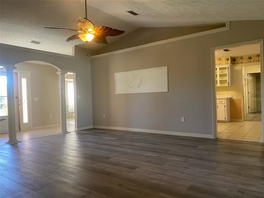 5881 Southwest 86th Place Ocala, FL 34476 - Photo 3 of 18 a view of an empty room with wooden floor and a window