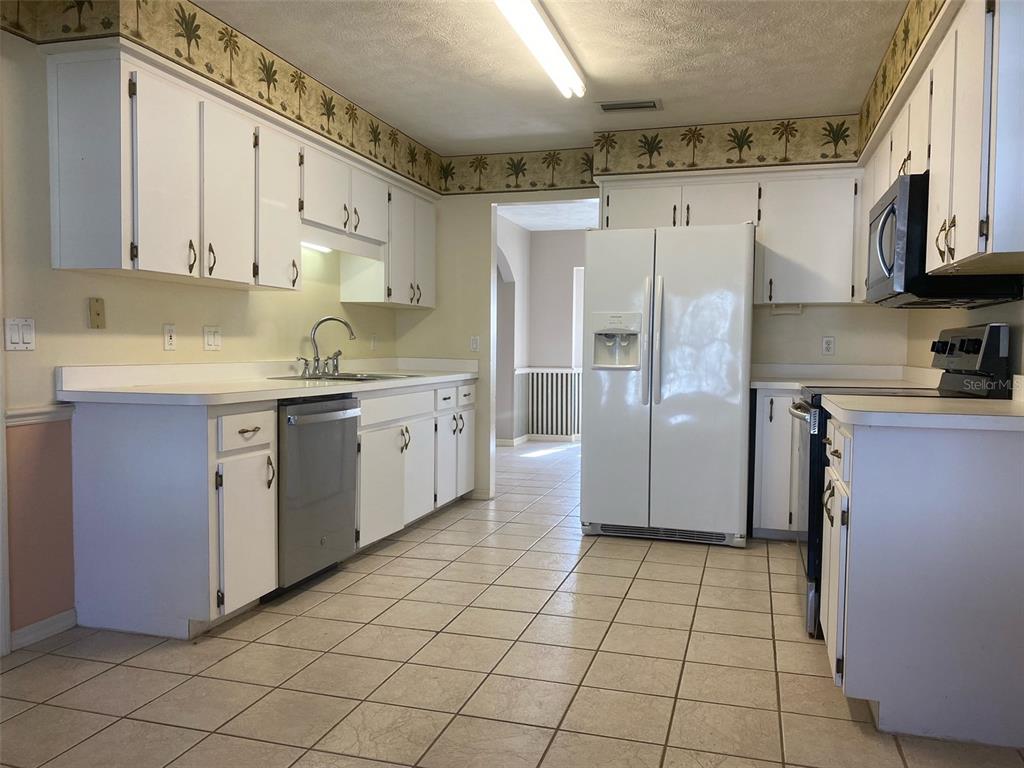 5881 Southwest 86th Place Ocala, FL 34476 - Photo 7 of 18 a kitchen with stainless steel appliances a refrigerator sink and cabinets