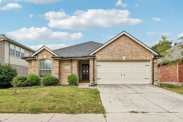 a view of a white house next to a yard and a large tree
