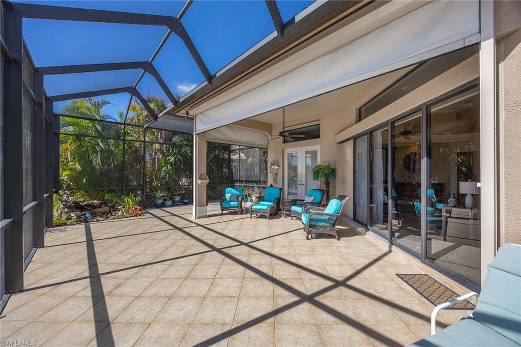 146 Windward Cay Naples, FL 34114 - Photo 25 of 33 a view of a patio with table and chairs potted plants with floor to ceiling window and potted plants