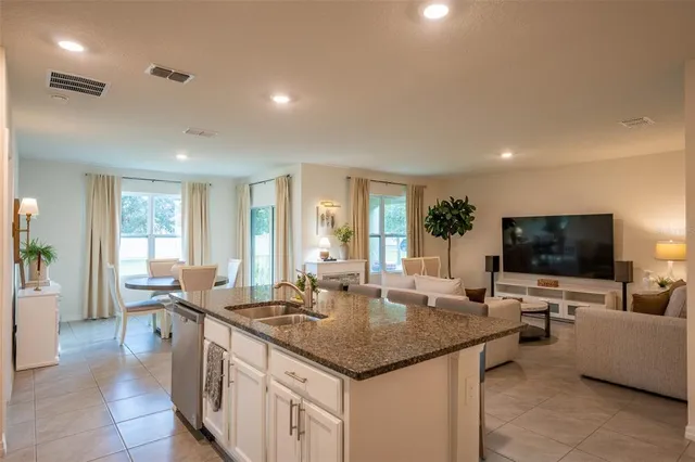 a living room with granite countertop couches and flat screen tv