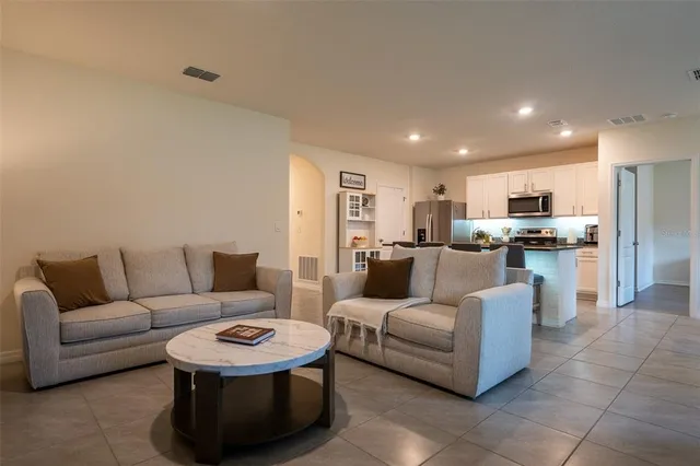 a living room with furniture and kitchen view