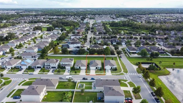 an aerial view of multiple houses with a swimming pool