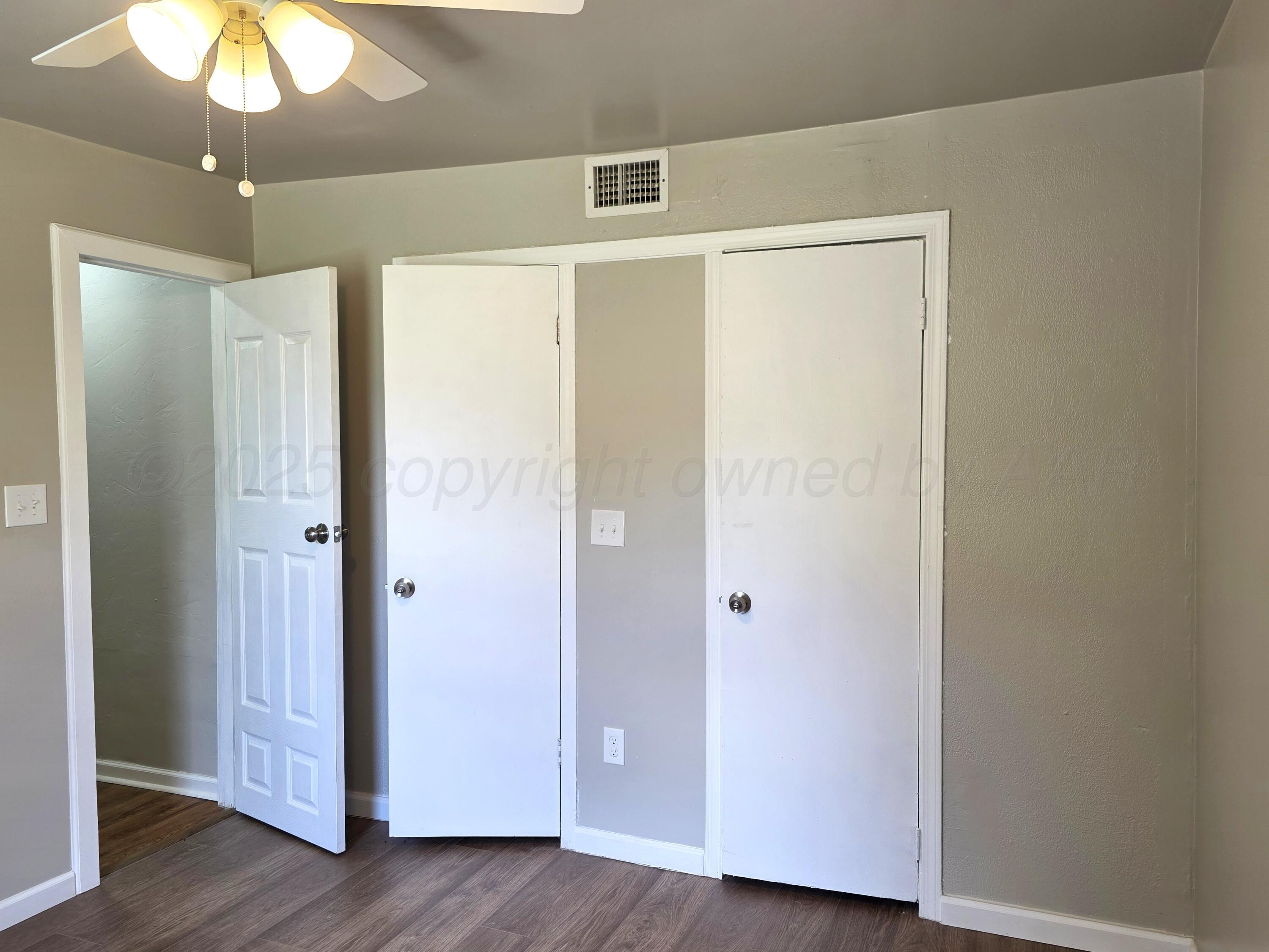 309 Southwest 40th Avenue Amarillo, TX 79110 - Photo 8 of 15 a view of an empty room with wooden floor and a ceiling fan