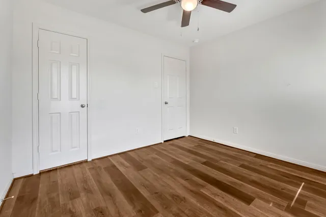 a view of empty room with wooden floor