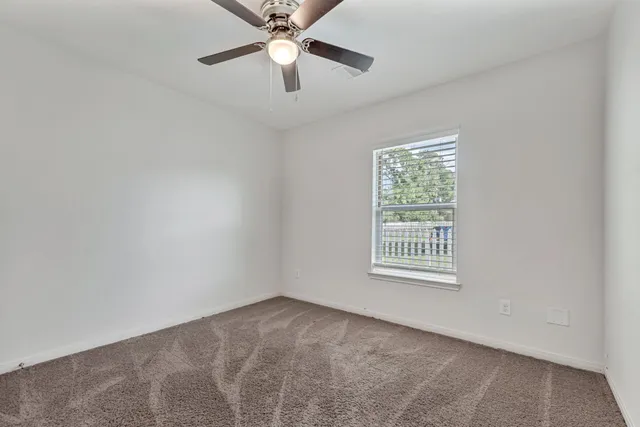 an empty room with a chandelier fan