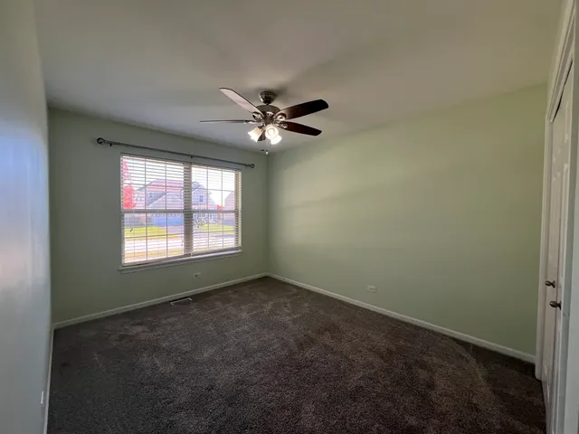 an empty room with fan and windows