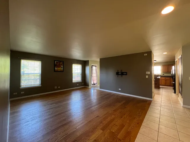 a view of a hallway with wooden floor and a living room