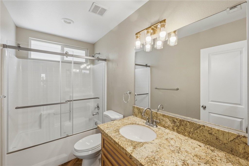 956 West Tibbot Street Rialto, CA 92377 - Photo 6 of 37 a bathroom with a granite countertop sink toilet a mirror and shower
