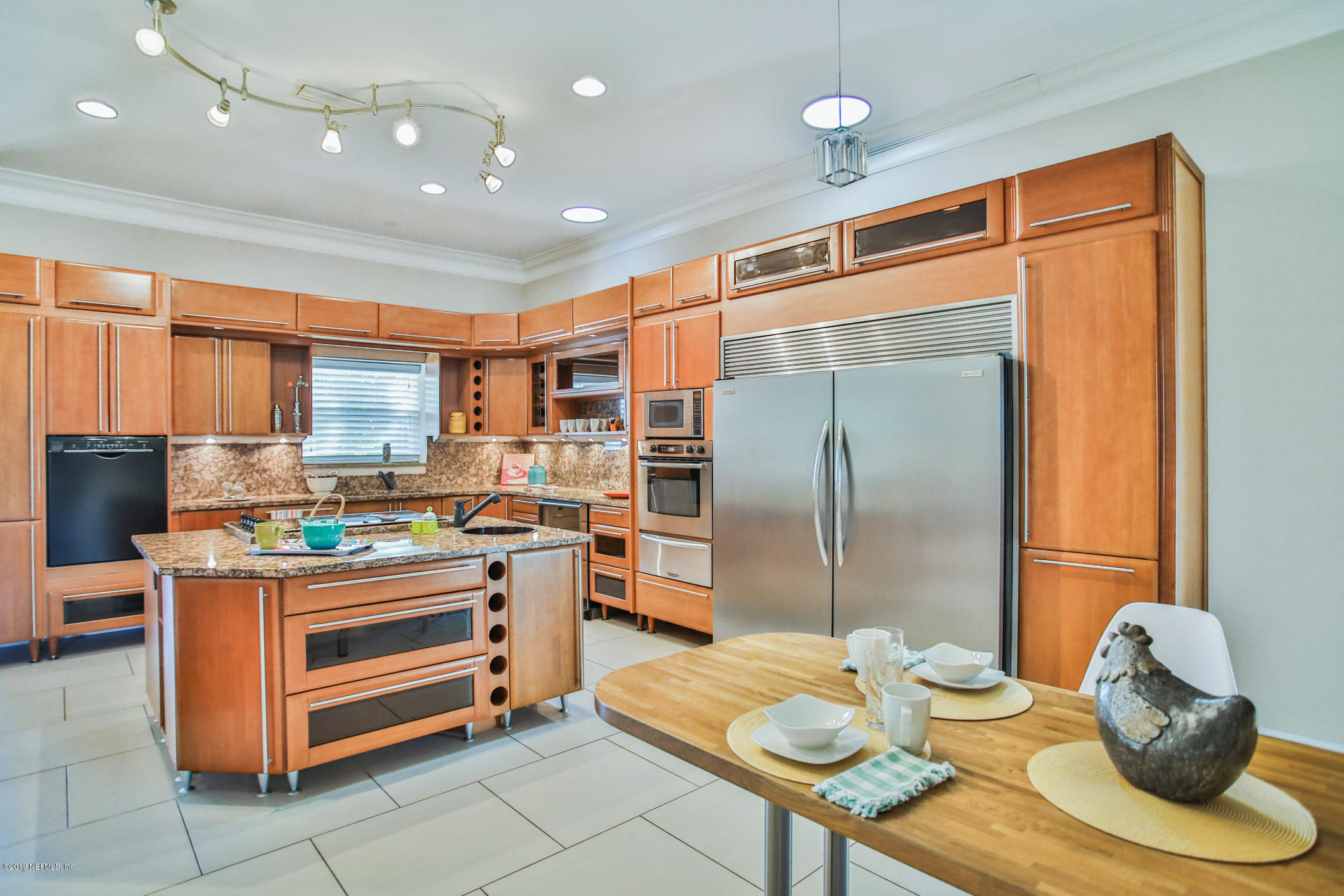 7936 Pine Lake Road Jacksonville, FL 32256 - Photo 22 of 70 a kitchen with stainless steel appliances kitchen island granite countertop a table chairs and a refrigerator