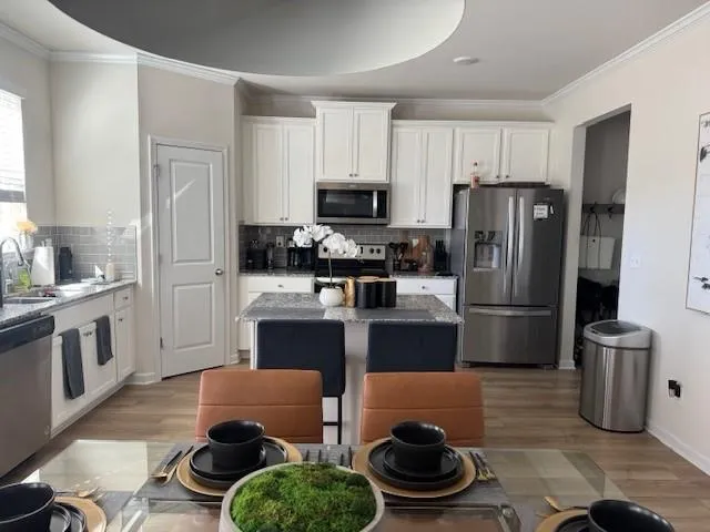 a kitchen with stainless steel appliances a refrigerator a stove a sink and a stove