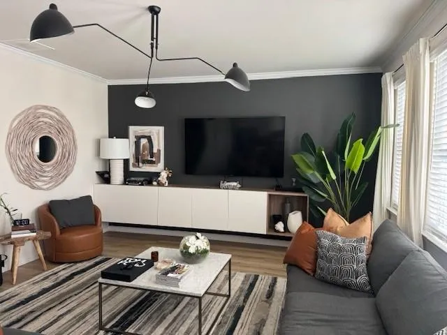 a living room with furniture a flat screen tv and a window