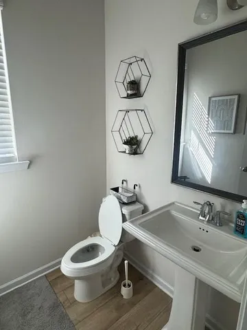 a bathroom with a toilet sink and mirror