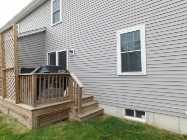 a view of a house with a deck and a yard