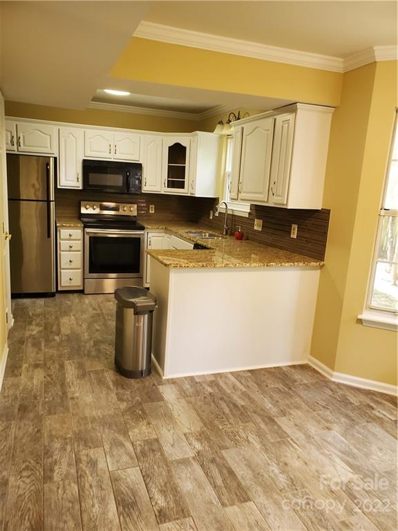8919 Vicksburg Road Charlotte, NC 28227 - Photo 12 of 22 a kitchen with stainless steel appliances granite countertop a stove a sink and a refrigerator