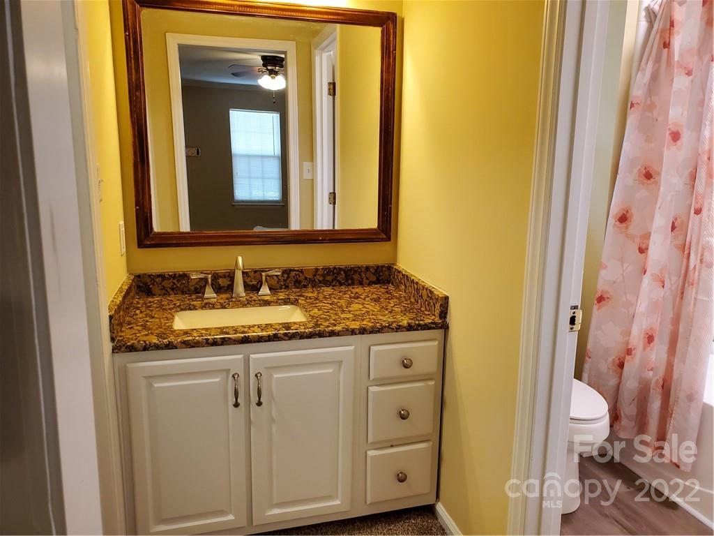 8919 Vicksburg Road Charlotte, NC 28227 - Photo 14 of 22 a bathroom with a granite countertop sink and a mirror