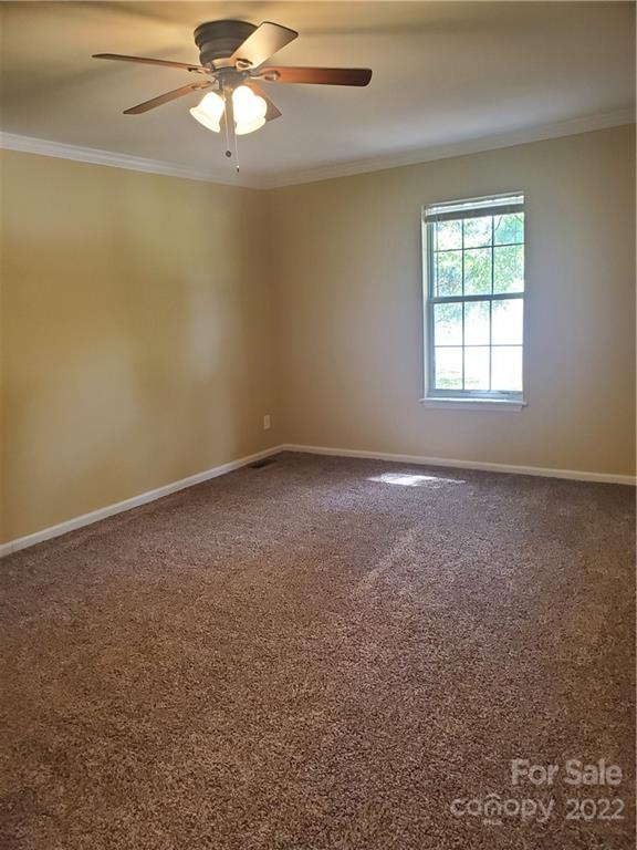 8919 Vicksburg Road Charlotte, NC 28227 - Photo 16 of 22 an empty room with a window and a fan