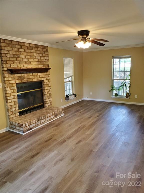 8919 Vicksburg Road Charlotte, NC 28227 - Photo 8 of 22 a view of an empty room with wooden floor fireplace and a window