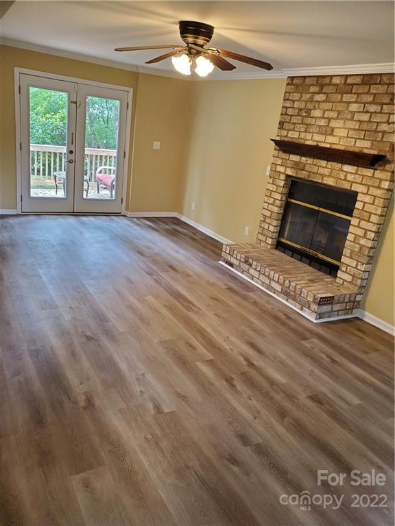 8919 Vicksburg Road Charlotte, NC 28227 - Photo 9 of 22 a view of an empty room with wooden floor fireplace and a window