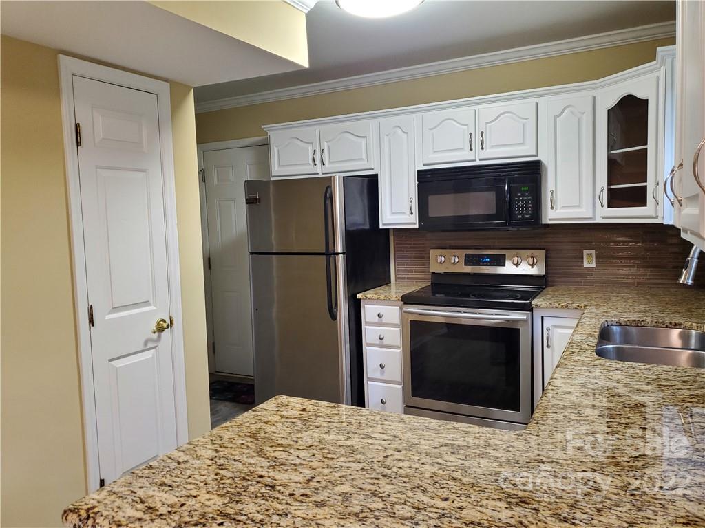 8919 Vicksburg Road Charlotte, NC 28227 - Photo 10 of 22 a kitchen with stainless steel appliances granite countertop a refrigerator stove and microwave