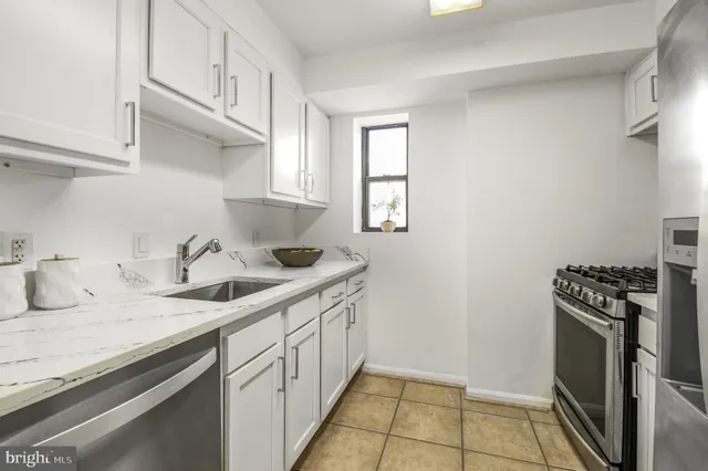 a kitchen with granite countertop a sink stove and cabinets