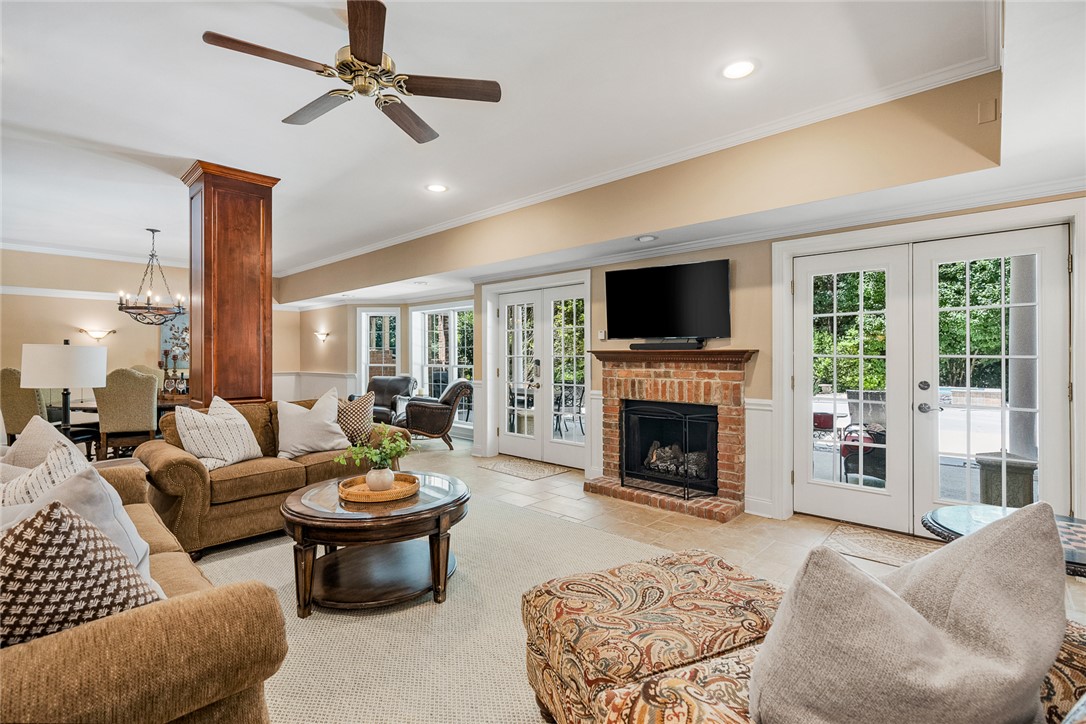 200 Graylyn Drive Anderson, SC 29621 - Photo 31 of 48 Elegant living space featuring a cozy fireplace and multiple glass French doors leading to outdoor areas.