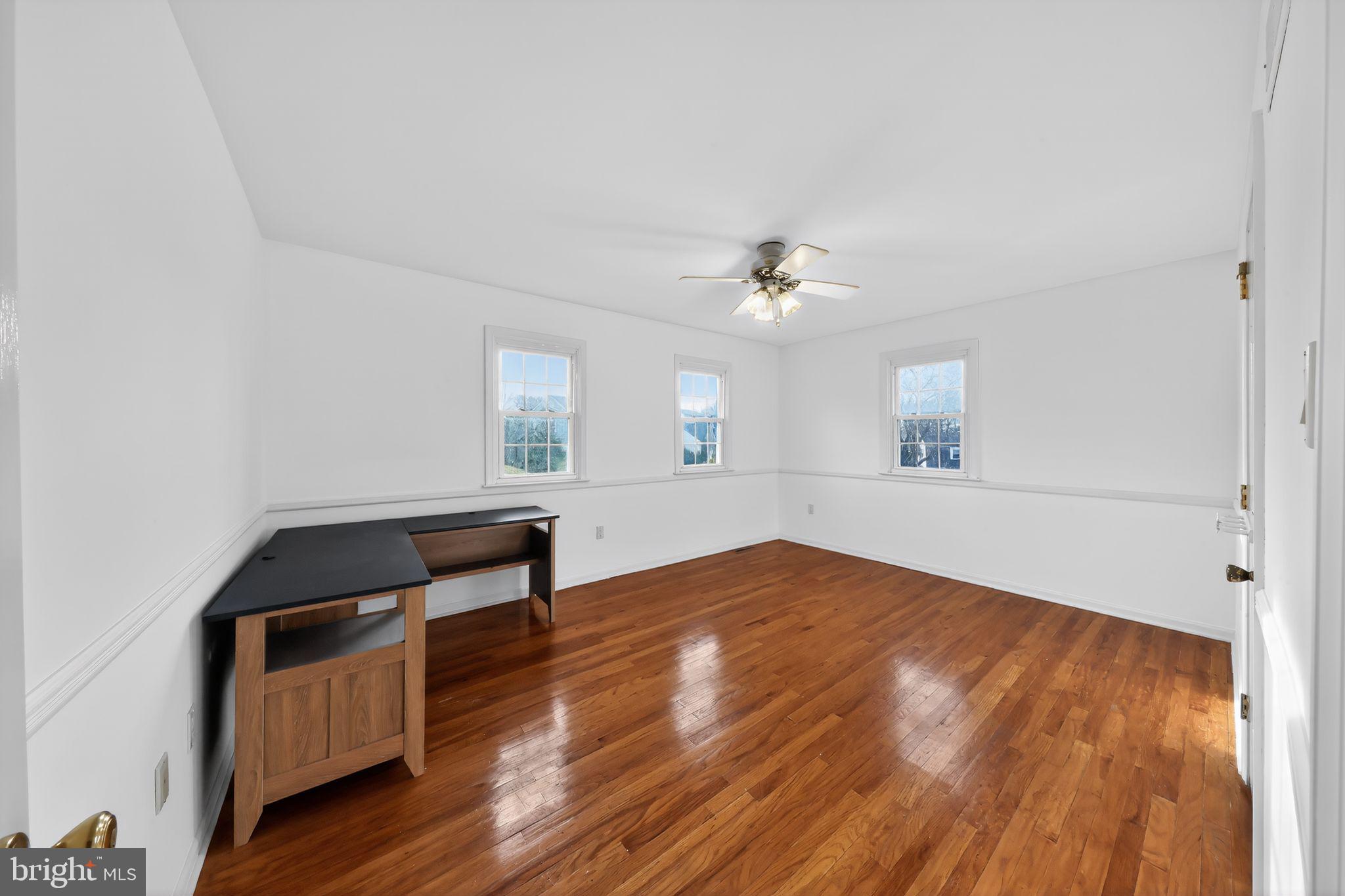 6 Kings Grant Road Hockessin, DE 19707 - Photo 17 of 24 a view of an empty room with wooden floor and a window