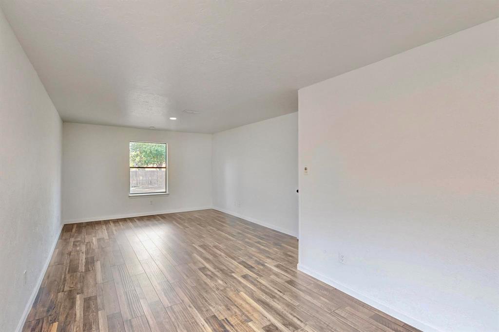 3965 Singleleaf Lane Fort Worth, TX 76133 - Photo 29 of 39 Bright interior space featuring wood-finish flooring, a single window with a framed outdoor scene, white painted walls, and recessed ceiling lighting
