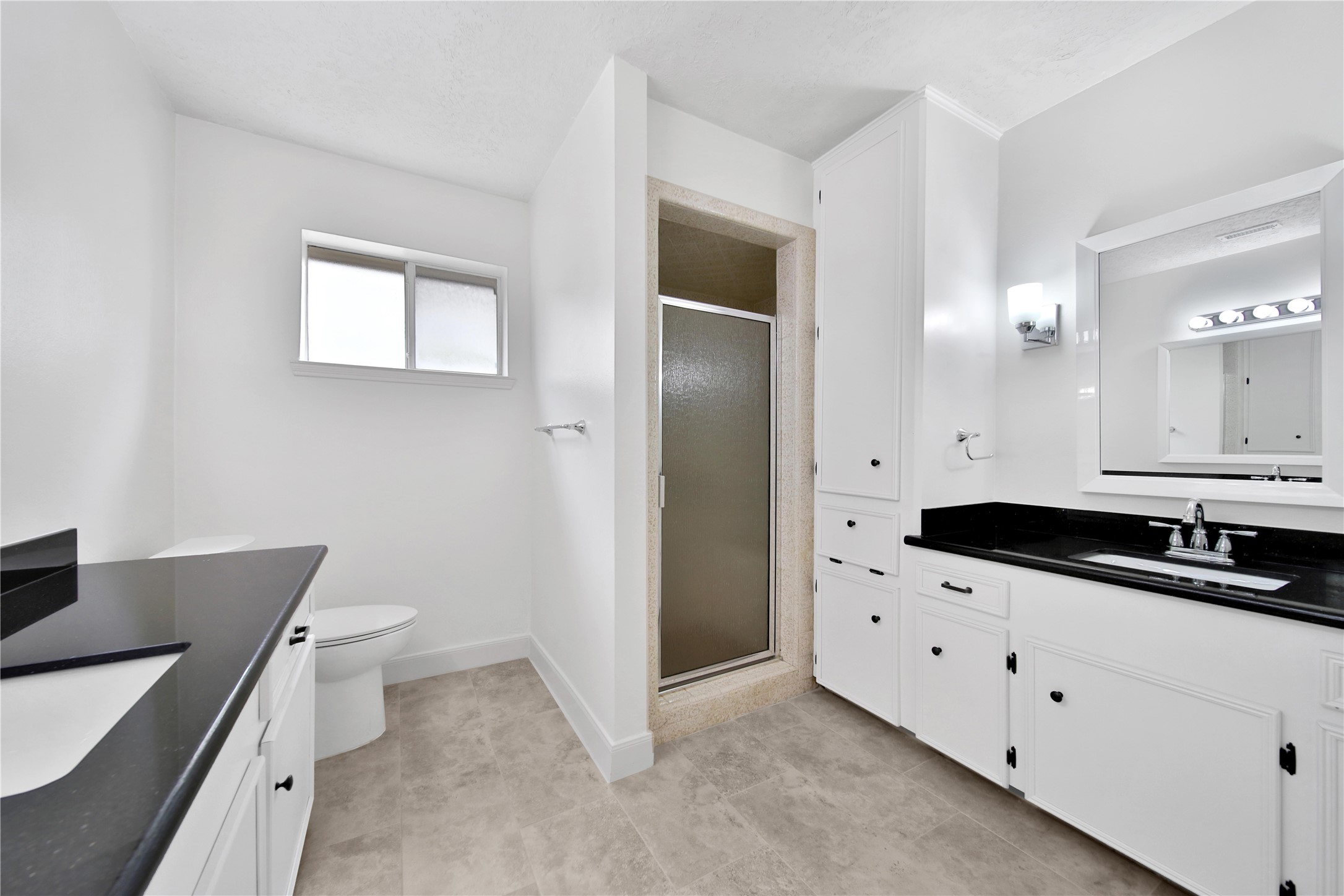 9411 Roos Road Houston, TX 77036 - Photo 26 of 41 a bathroom with a sink a toilet a mirror and vanity