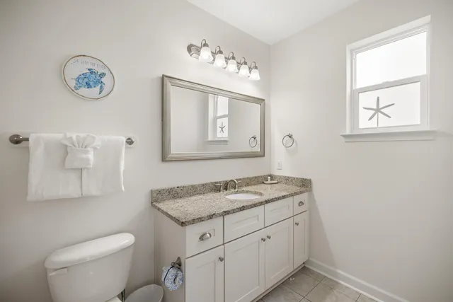 a bathroom with a granite countertop sink mirror and a bathtub