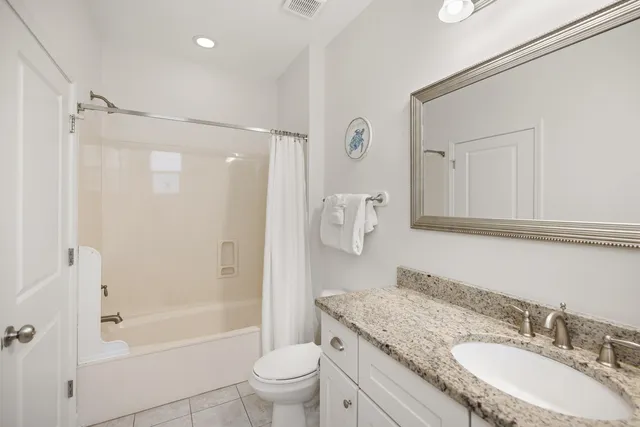 a bathroom with a granite countertop tub sink and mirror