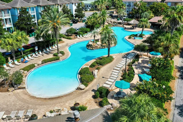 a view of a brick house next to a yard with a fountain