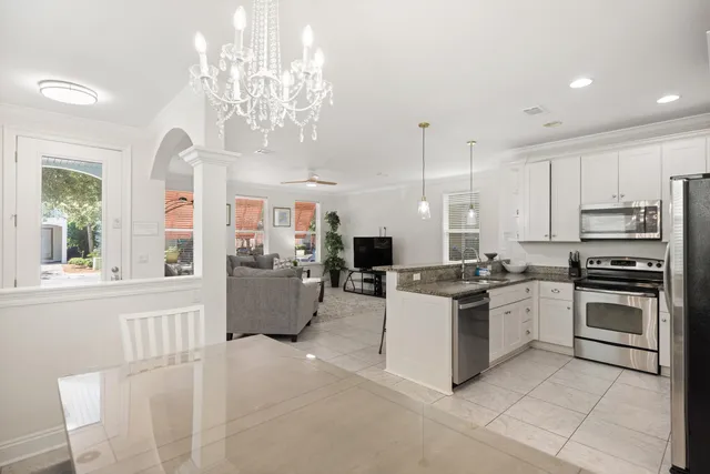 a living room with furniture a table and kitchen view