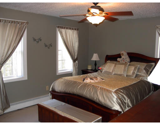 98 Coffey Hill Road Ware, MA 01082 - Photo 5 of 9 a bedroom with a bed and a chandelier