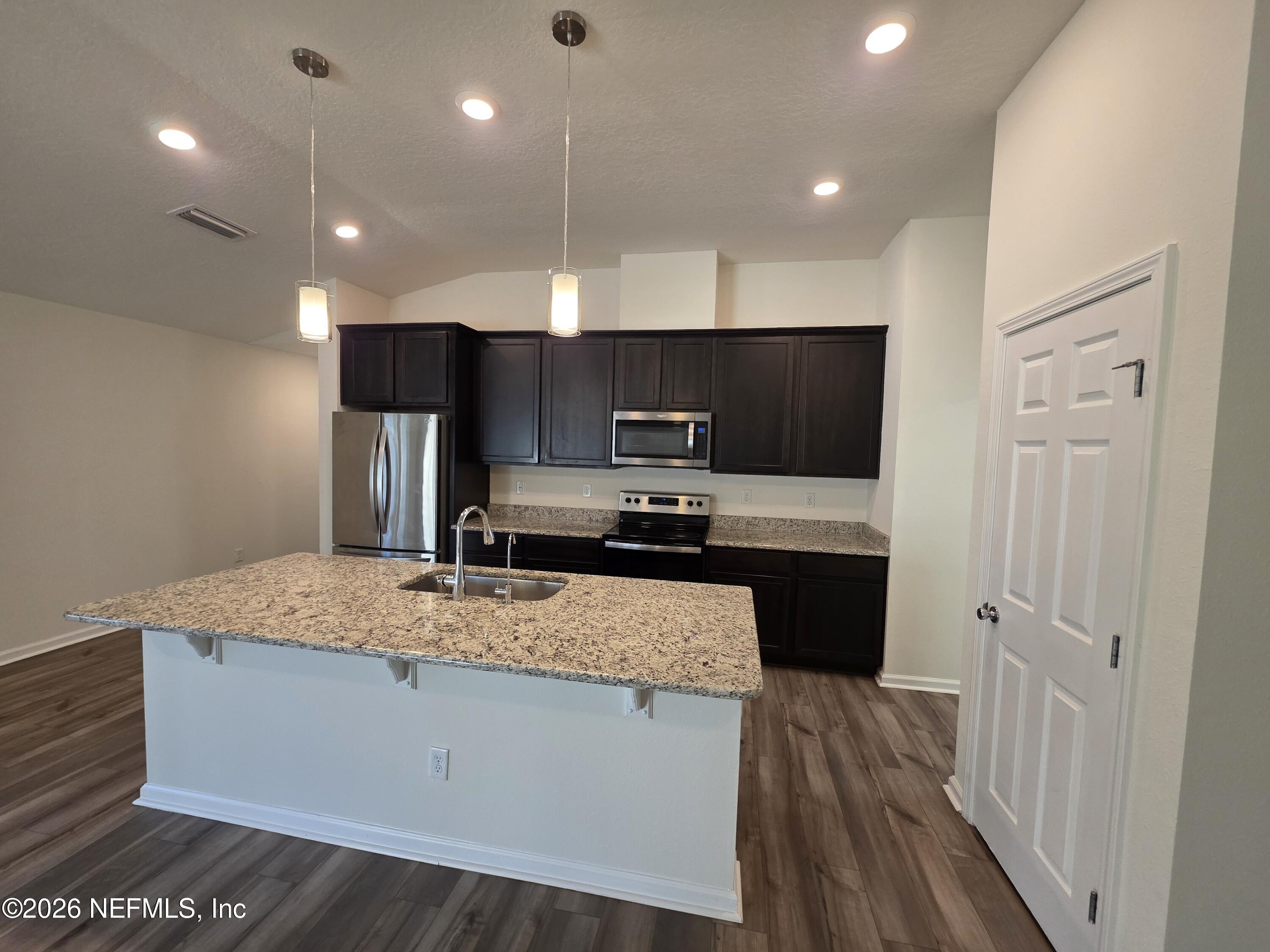 3035 Lucille Lane Middleburg, FL 32068 - Photo 11 of 39 a kitchen with kitchen island a sink stainless steel appliances and cabinets