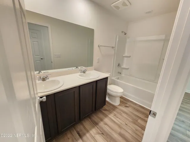 a lobby with wooden floor and stairs
