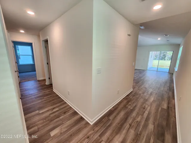 a view of a hallway with wooden floor