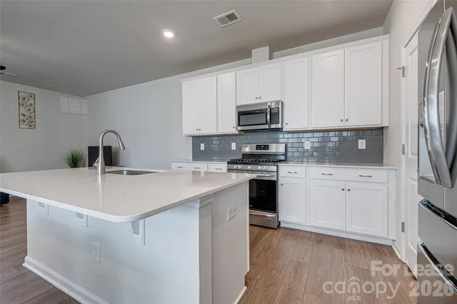 a kitchen with appliances a sink and cabinets