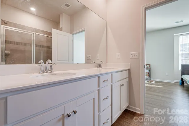 a spacious bathroom with double sink and a large mirror