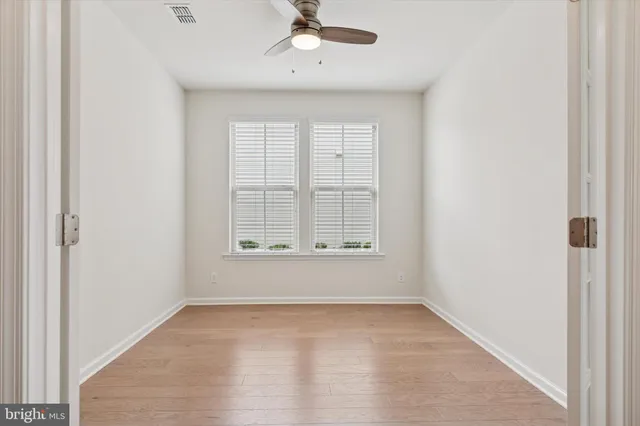 an empty room with a window and a ceiling fan
