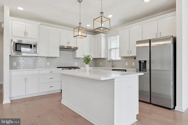 a kitchen with stainless steel appliances a refrigerator sink and microwave