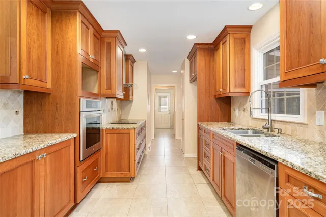 a kitchen with stainless steel appliances granite countertop a stove a sink and a refrigerator
