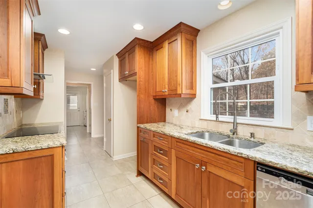 a kitchen with granite countertop a sink and a stove