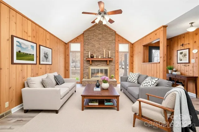 a living room with furniture fireplace and a large window