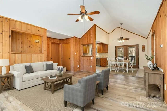 a living room with furniture a dining table and a chandelier