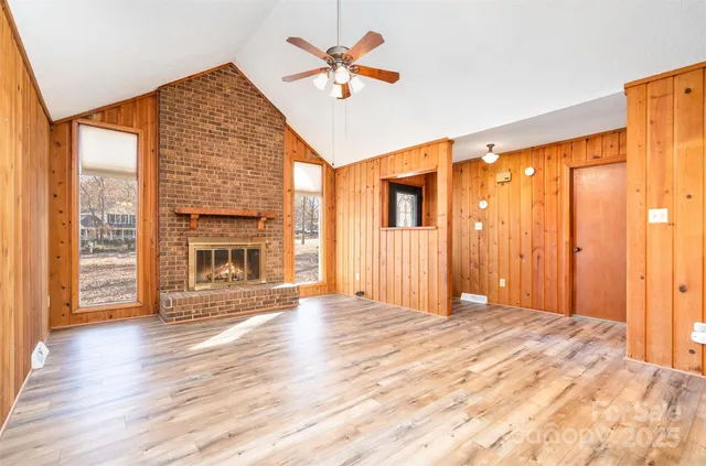 an empty room with wooden floor and a ceiling fan