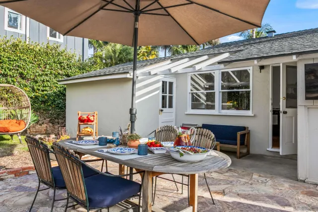 a patio with a table and chairs under an umbrella